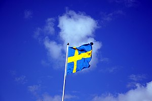 Zweedse vlag met daarachter een blauwe lucht