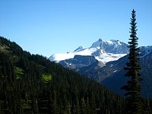Veduta del monte Garibaldi e di The Table che dominano una foresta di conifere.