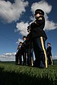 A US Army honor guard stands at parade rest, waiting to execute a rifle salute. Dignitaries performed the first burials at the facility, marking its official opening.