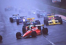 Photo de nombreuses voitures de Formule 1 sur une piste détrempée