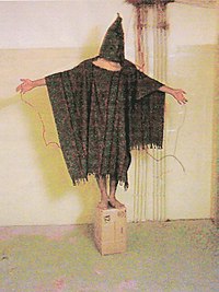 Satar Jabar standing on a box with wires connected to his body