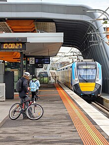 A modern train (HCMT) approaches platform 2 at the newly elevated Carnegie railway station.