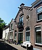 Voormalig woonhuis, nu bedrijfspand met rode bakstenen tuitgevel en een zadeldak (Gouda-Centrum)