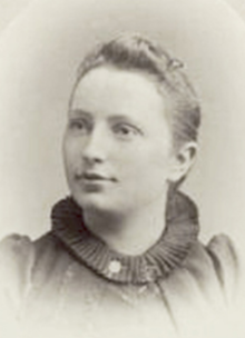Loretta Leonard Shaw, a young white woman with her fair hair swept back away from her face, wearing a dark pleated collar on her dress.