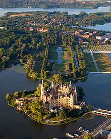 Schwerin Palace, historical ducal seat of Mecklenburg, Germany - an example of pompous renaissance revival for representation purposes (built in 1857) Schwerin Castle Aerial View Island Luftbild Schweriner Schloss Insel See.jpg