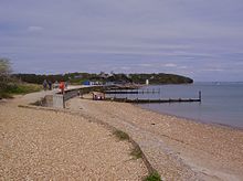 The seafront at St Helens, with the white sea mark of the old church tower in the distance Seafront, St Helens, IW, UK.jpg