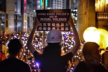 Protesters holding signs protesting against alleged police sexual violence