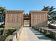 Entrée du parc du château du Nessay à Saint-Briac-sur-Mer en Ille-et-Vilaine. Le porche a été élargi lors des grands travaux achevés en 2018. Il est encadré par deux bâtiments annexes symétriques.