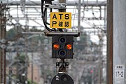 駅構内にあった架線電源識別標識、交流通電中の表示（赤色横二灯）。