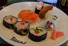 Assorted sushi, on a plate with the Todai logo emblazoned on it.