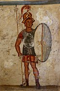 Fresco of an ancient Macedonian soldier (thorakitai) wearing chainmail armor and bearing a thureos shield. Thueros affresco.jpg