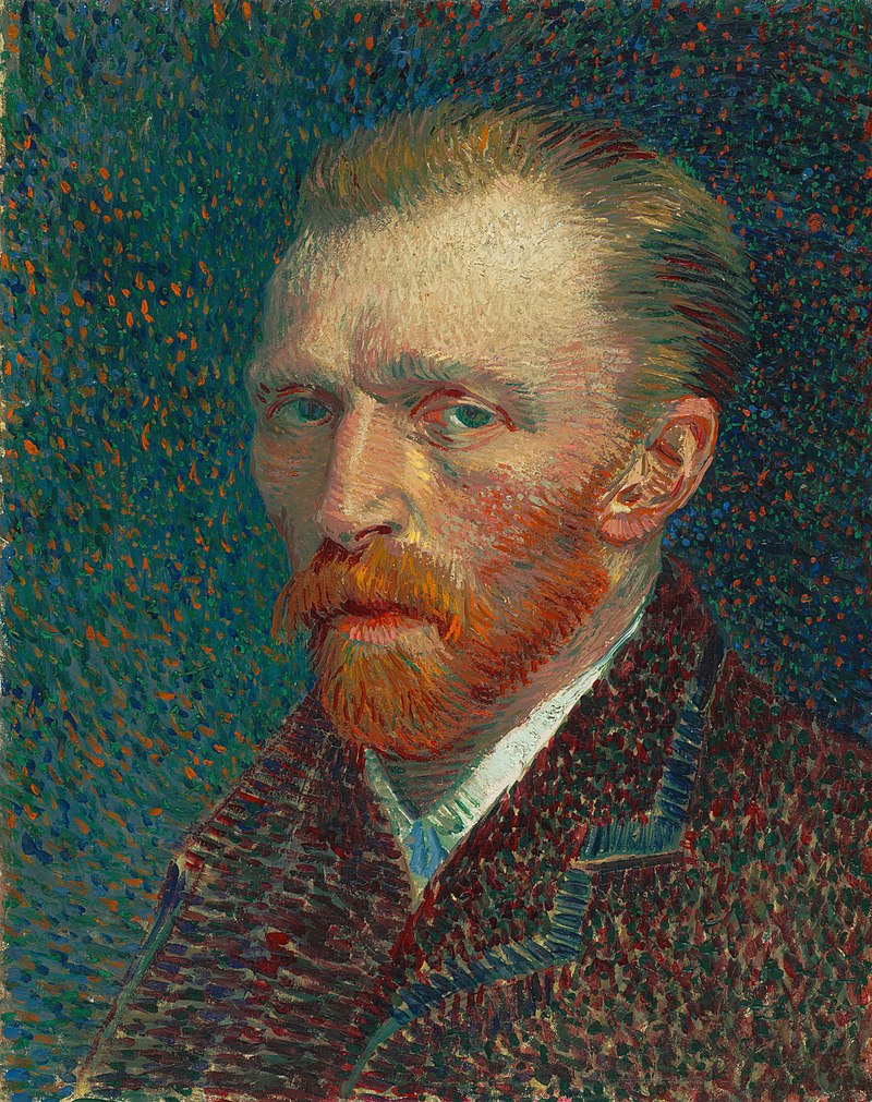 An intense man with close cropped hair and red beard gazes to the left.