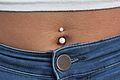 A navel piercing with white closures