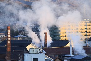 手前右側の白色のものは亀齢五号蔵煙突。昭和初期の建築。円形RC造。