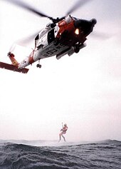 Coast Guard aviation MH-60 Jayhawk helicopter with a rescue swimmer 221697.jpg