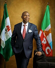 a suited man standing between two flags