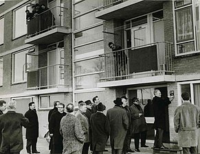 Wethouder van der Borg schroeft het eerste huisnummerbord in Nederland met zowel straat als huisnummer in cijfers op een flatgevel (1967)