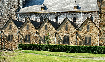 Le mur de la nef romane (en moellons gris) et les chapelles latérales néo-romanes (en moellons bruns).