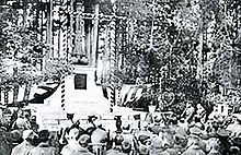 Vieille photographie en noir et blanc d'une cérémonie d'hommage devant un monument funéraire japonais