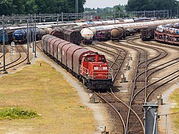 foto met sporen, veel goederen­wagons en een goederentrein