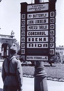 Soldier reading the announcement of Opera House in Odesa during the Romanian occupation in 1942. The name of the city in Romanian is spelled as Odesa with one letter 's'. Odessa opera house advertisement transnistria times.jpg