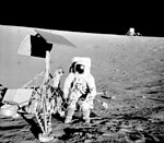 Photo noir et blanc de la sonde sur la lune avec un astronaute à côté.
