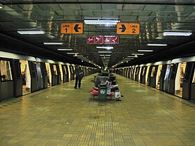 . station souterraine avec un quai central et deux voies avec des rames portes ouvertes