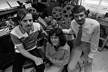 Two men and a woman sitting in a room full of film equipment