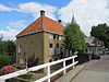 Rechthoekig huis, later verhoogd en uitgebreid. Rechte kroonlijst. Aardig gelegen aan het water. Vormt een geheel met het buurnummer