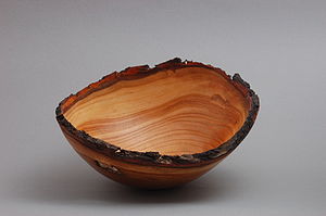 A natural edge turned wood bowl made of peach wood