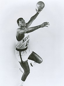 Photo en noir et blanc d'un joueur en train de tenter un tir de la main gauche.
