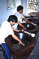 عمال يقومون بتثبيت (إزالة الاخضرار) أوراق الشاي في مزرعة صينية، 1987.