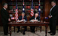 George W. Bush and John Howard signing a treaty inside the Commonwealth Parliament Offices.