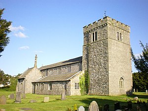A stone church seen from the northwest with a battlemented tower