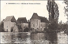 Carte postale ancienne en noir et blanc représentant trois bâtiments alignés enjambant un cours d'eau