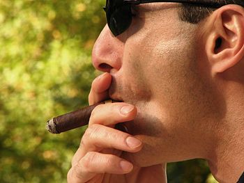 English: Man smoking a cigar.