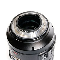 La baionetta di un obiettivo moderno, il Micro-Nikkor AFS VR 105mm con attacco F-mount che mostra i controlli per l'apertura (in alto a sinistra) e i contatti per la CPU (in basso)