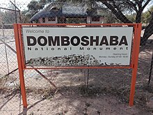 Знак на входных воротах национального памятника Домбошаба, Ботсвана.jpg