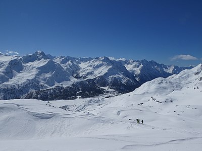 Blick Richtung Süden auf den westlichen Teil der Bernina-Alpen (Piz da la Margna, Cima di Rosso, Cima di Castello, Piz Cengalo, Piz Badile) und Maloja im Tal,