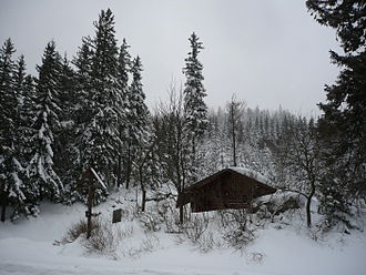 Blick auf das Wegkreuz und die Schutzhütte an der Passhöhe