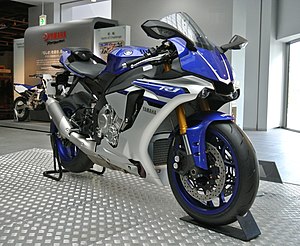 White streamlined motorcycle left side on a raised dais at an exhibition