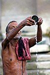 Un uomo esegue abluzioni nel Gange a Varanasi (Benares), India.