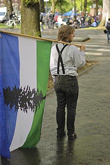 A man in Portland, Oregon with Cascadian flag on International Workers' Day, 2012 Cascadia Flag (7134901861).jpg