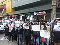 Demonstrators carrying placards with several hashtag slogans.