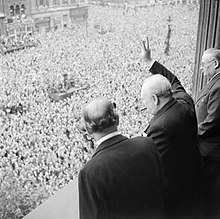 Winston Churchill (c) with Ernest Bevin (r) and Sir John Anderson (l) waving to the crowds in Whitehall on VE Day. Anderson joined the caretaker ministry but Bevin and his Labour colleagues did not. Winston Churchill waves to crowds in Whitehall in London as they celebrate VE Day, 8 May 1945. H41849.jpg