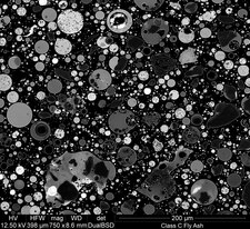 Fotomikrograf dibuat dengan mikroskop pemindai elektron (SEM) serta detektor pencar belakang: penampang partikel abu terbang pada perbesaran 750x