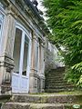 Latéral de la façade avec l'escalier et la porte.