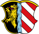 Gemeinde Alfeld Gespalten durch einen blauen Bach, vorne in Schwarz ein halber, rotbewehrter goldener Löwe, hinten fünfmal schräg geteilt von Rot und Silber.