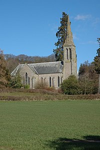 A stone church seen from the north. On the right is a narrow tower and spire, and projecting from the centre is the transept, all with lancet windows