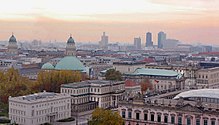 Farbfotografie in der Vogelperspektive von der Friedrichstadt. Links sind Deutscher und Französischer Dom, vorne in Unter den Linden ist das Alte Palais und im rechten Hintergrund sind die Hochhäuser vom Potsdamer Platz zu sehen.